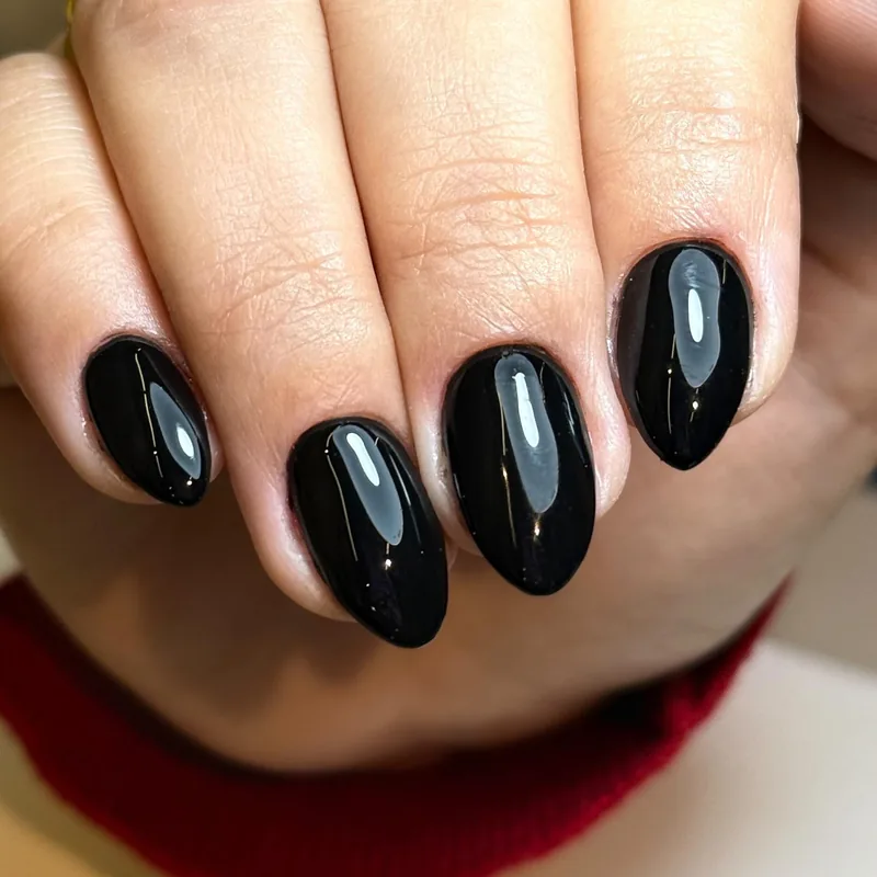 Unhas amendoadas pretas em gel — acabamento espelhado, cutícula intacta, sem vermelhidão