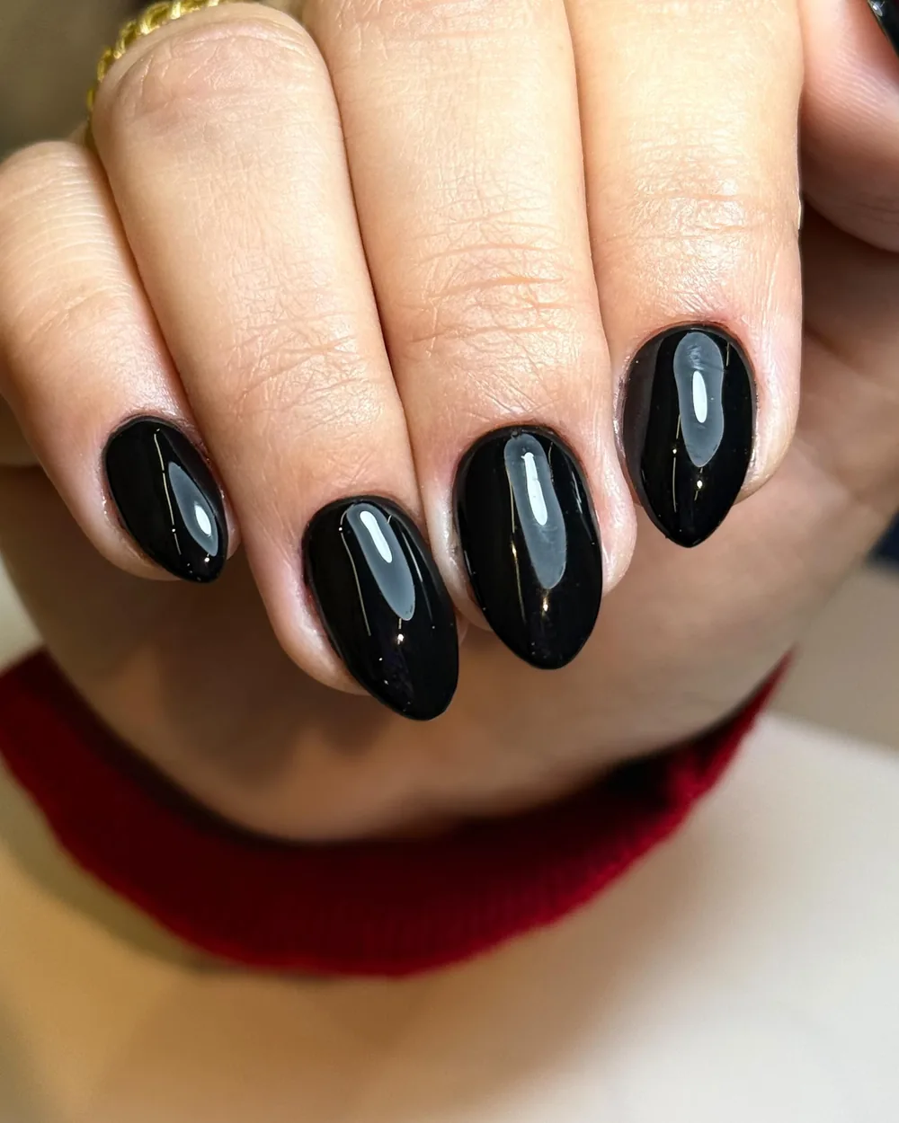 Unhas amendoadas em esmaltação preta em gel feitas na Esmalteria Laju — brilho espelhado e cutícula intacta